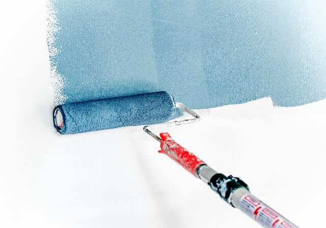Painting wall in blue colour using extension pole