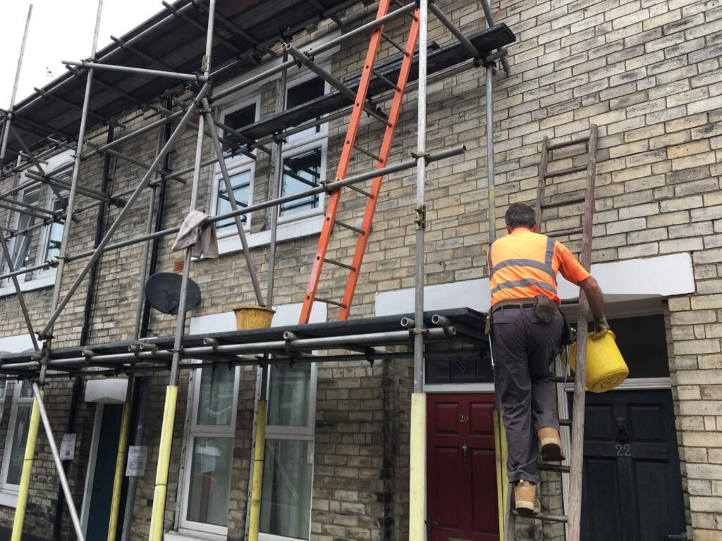 Scaffolder is climbing a ladder