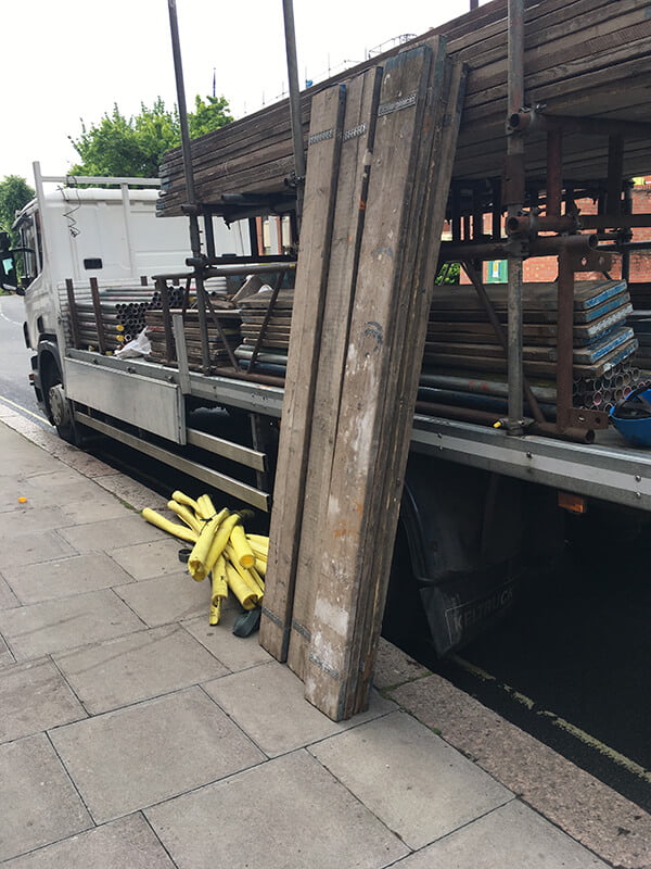 Scaffold board leaning against a lorry