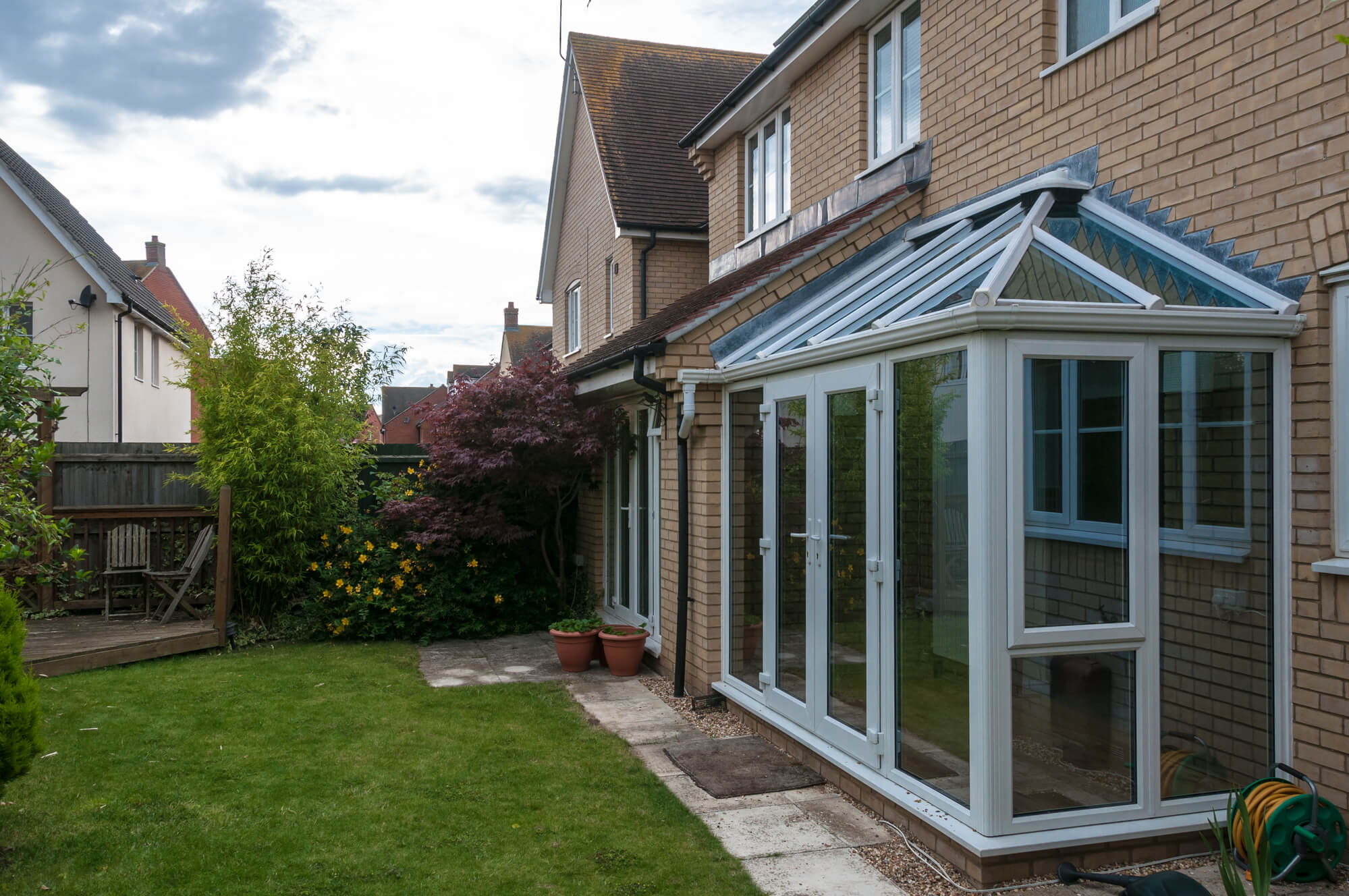 white upvc conservatory with a view to rear garden