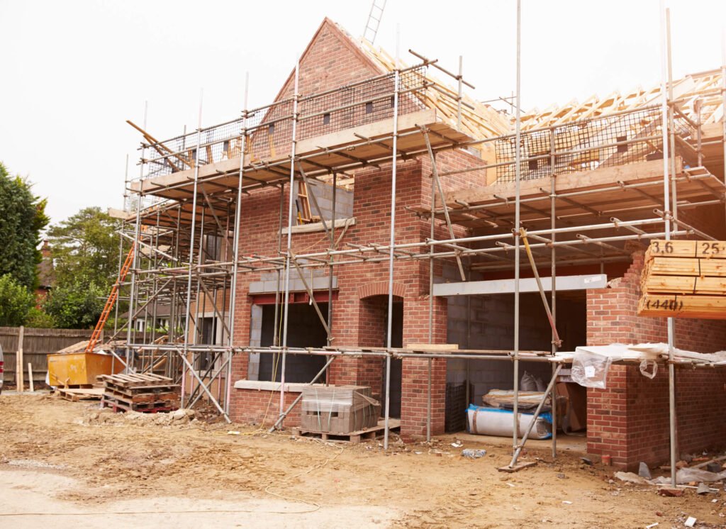 under construction detached house covered with scaffold