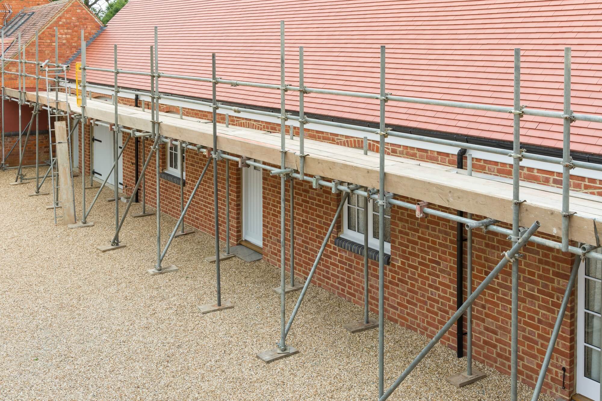 wide scaffolding for a gutter repair on a barn