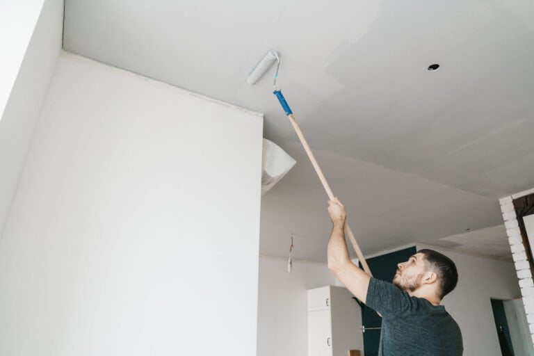 Man painting ceiling with a pole extension